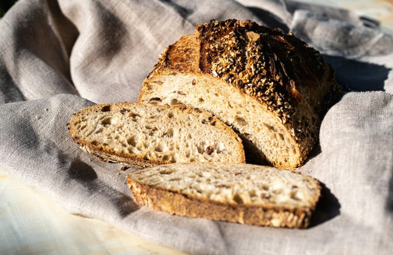 Sliced seeded rye loaf on a linen cloth
